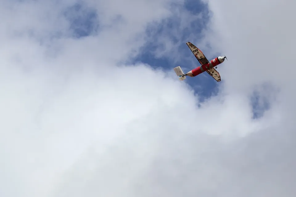 El Insomnio en vuelo sobre un cielo con nubes, con el fuselaje rojo y el número 8 en el ala